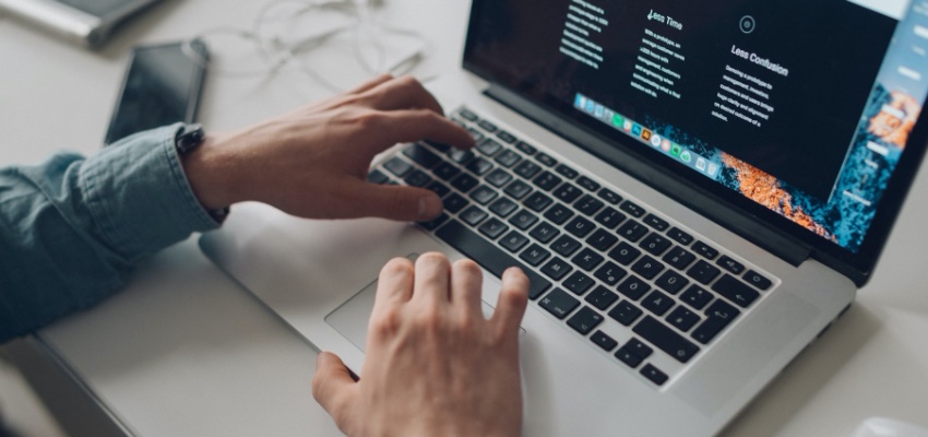 person wearing long-sleeve top working on laptop